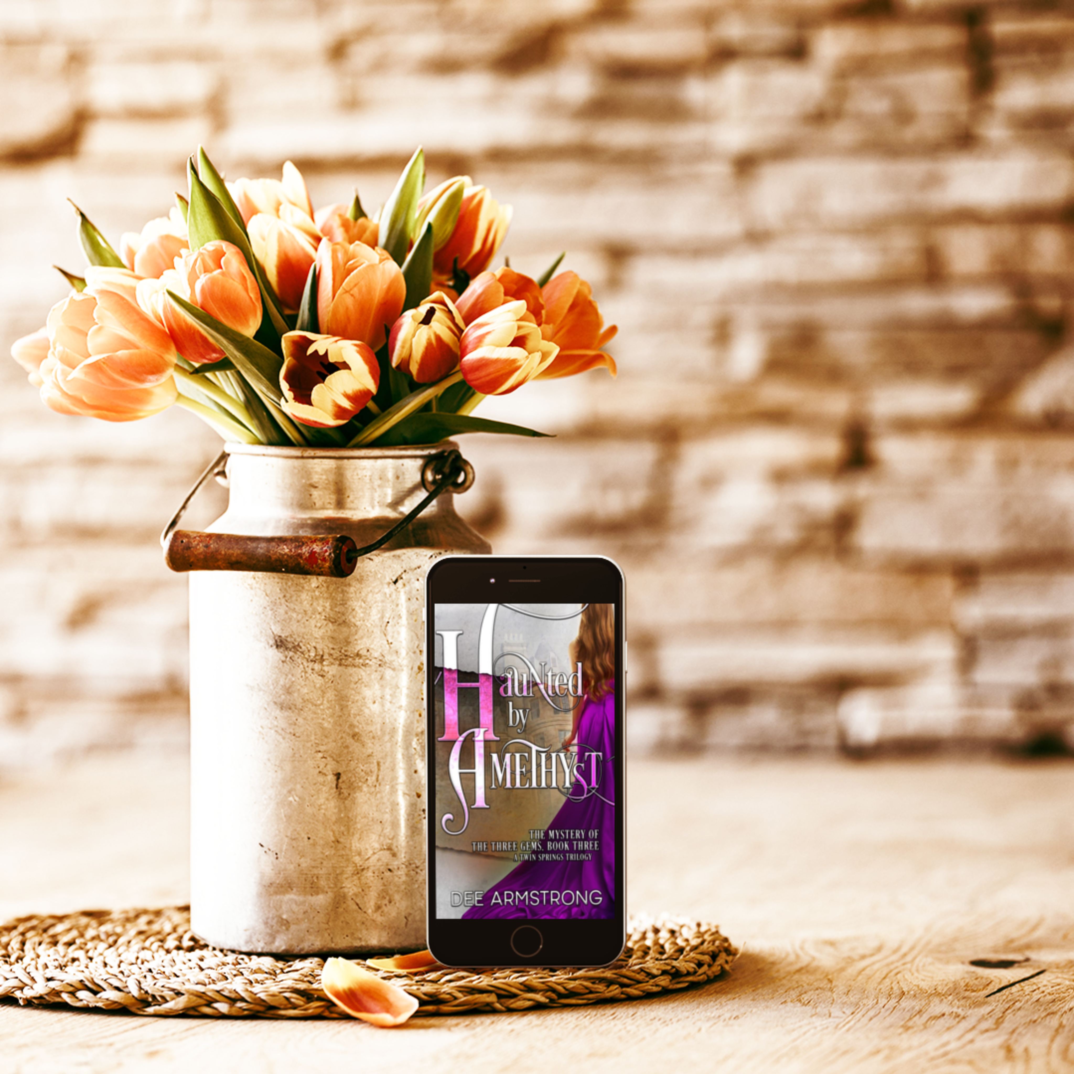 Phone displaying a book cover with tulips in a vase on a wooden surface