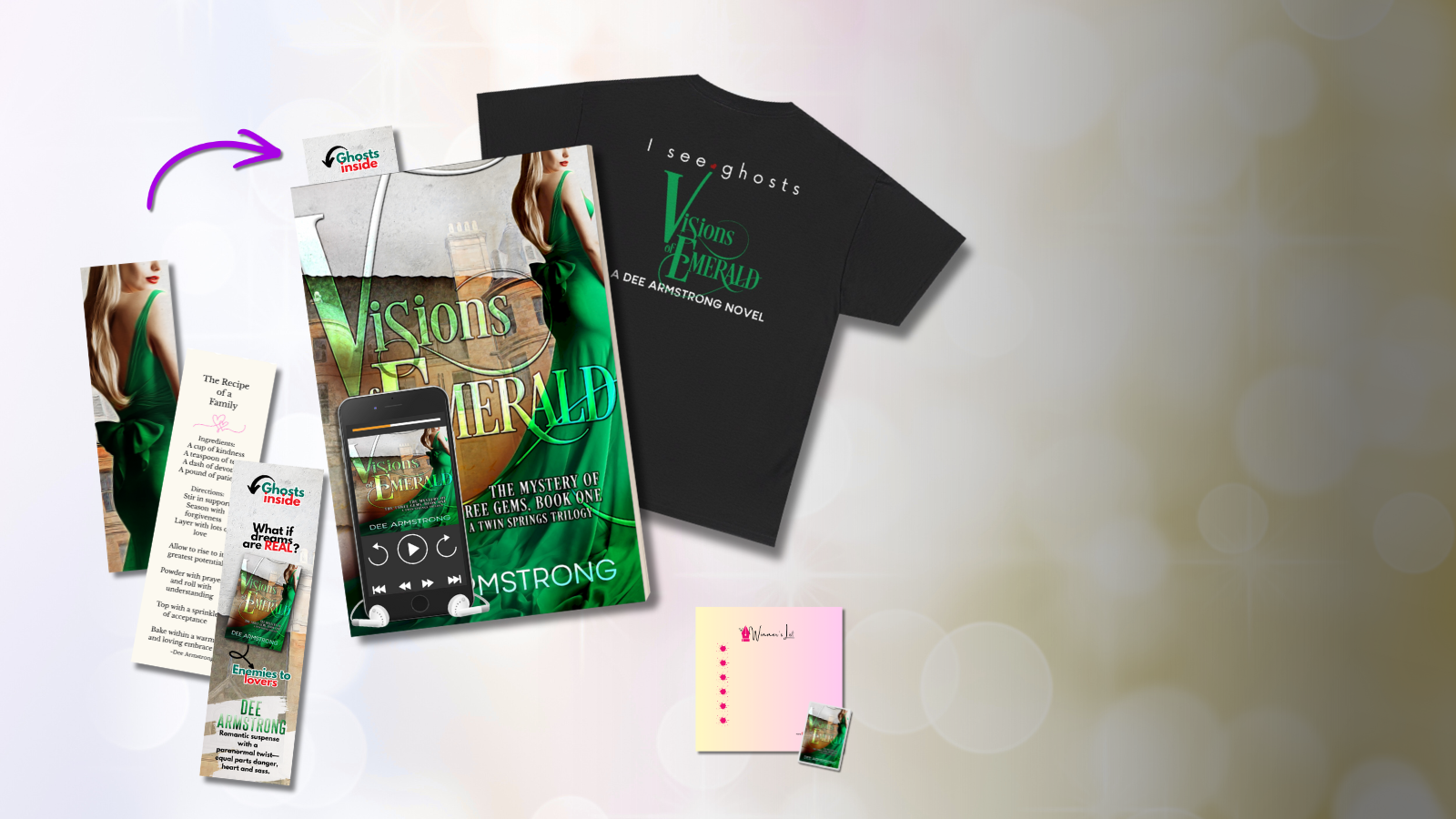 The Visions of Emerald Collection by Dee Armstrong: including a t-shirt, book, and smartphone app on a blurred background