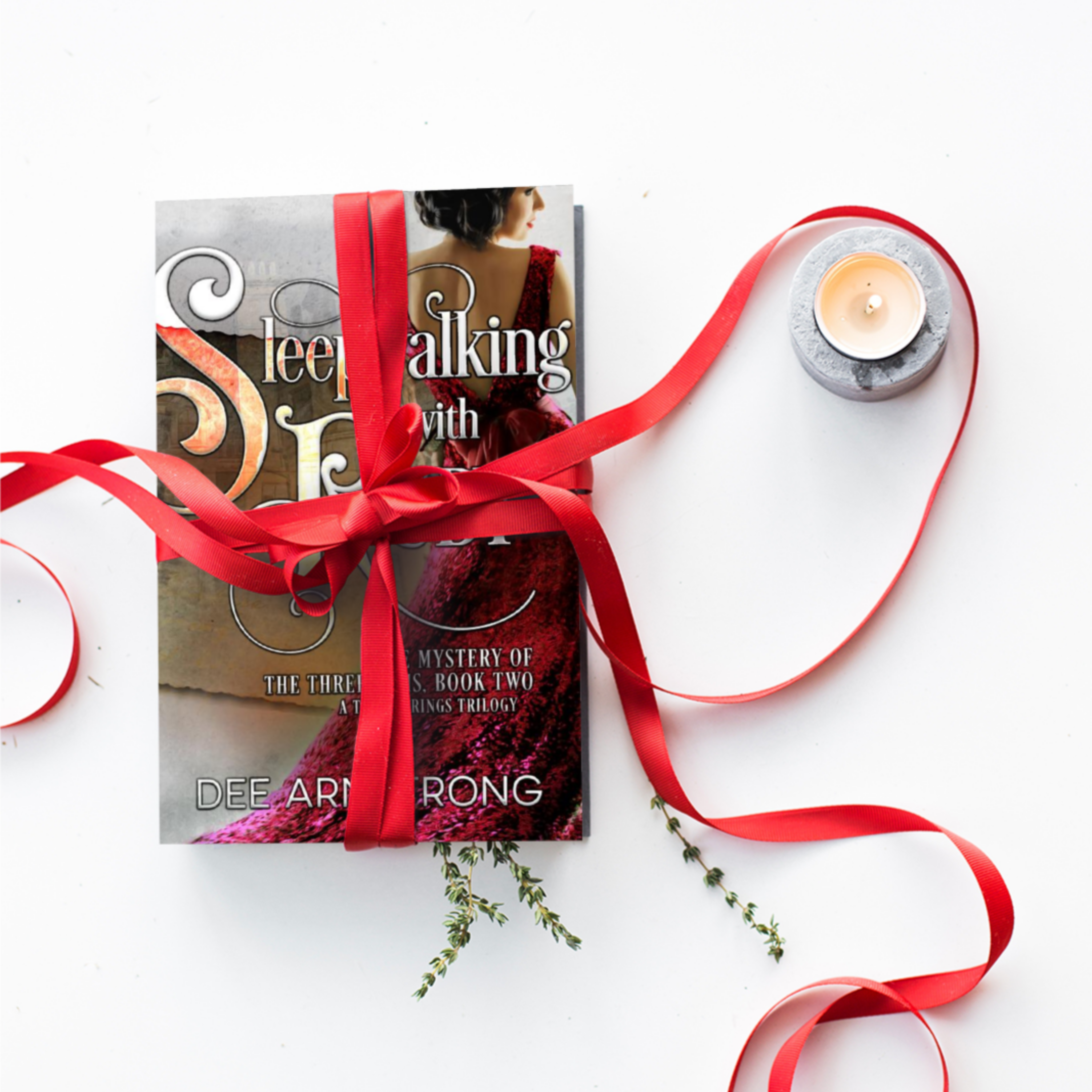 Book titled 'Sleeping with Ruby' by Dee Armstrong tied with a red ribbon on a white background.
