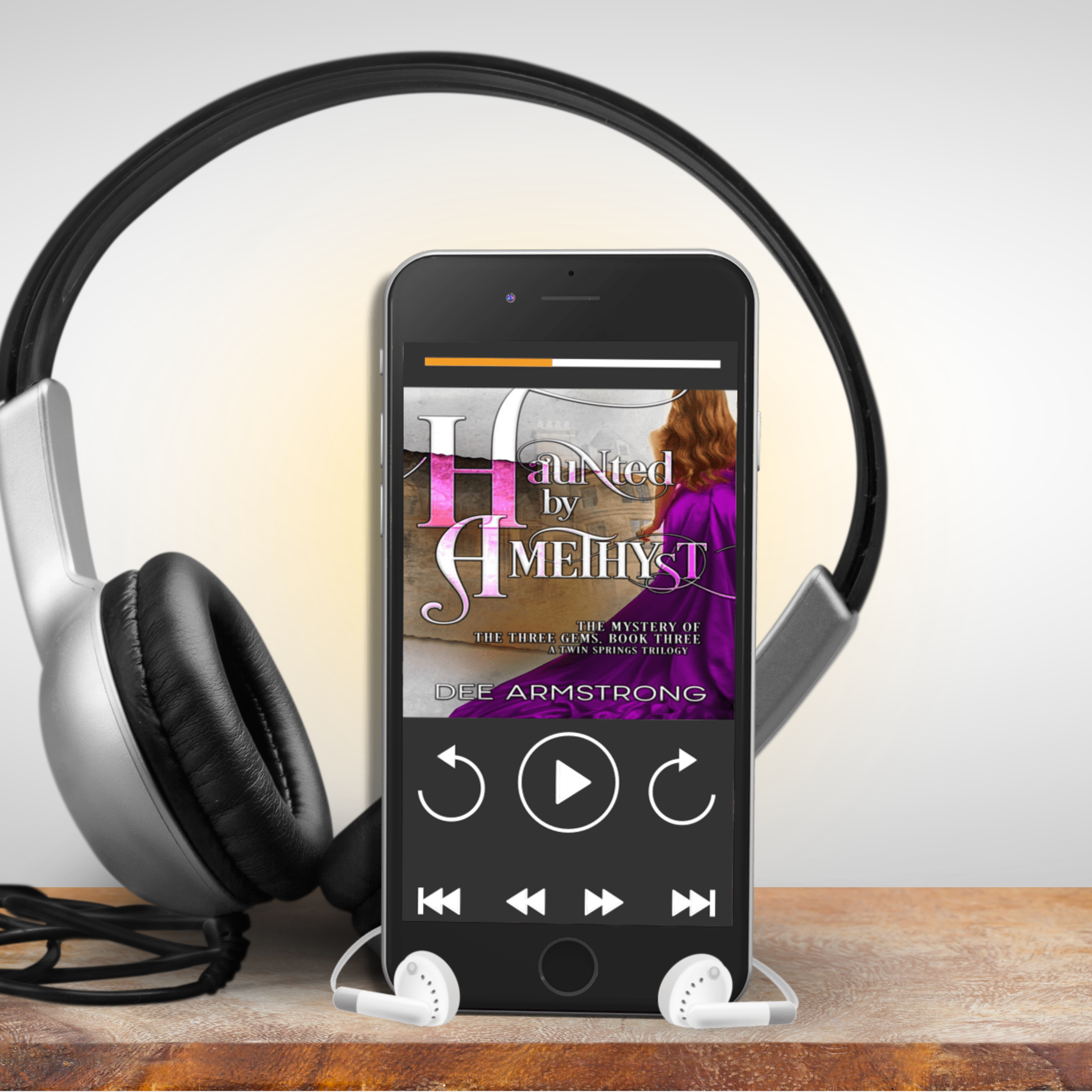 Phone displaying Haunted by a Amethyst audiobook cover with headphones on a wooden surface