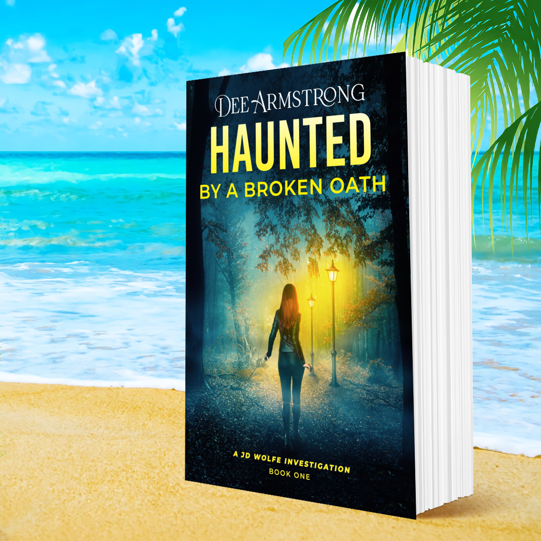 Book titled 'Haunted by a Broken Oath' by Dee Armstrong on a beach with ocean and palm trees in the background