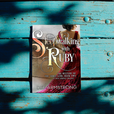 Book titled 'Sleepwalking with Ruby' by Dee Armstrong on a blue wooden surface