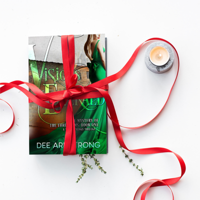 Book titled 'Visions of the Emerald' by Dee Armstrong with a red ribbon on a white background